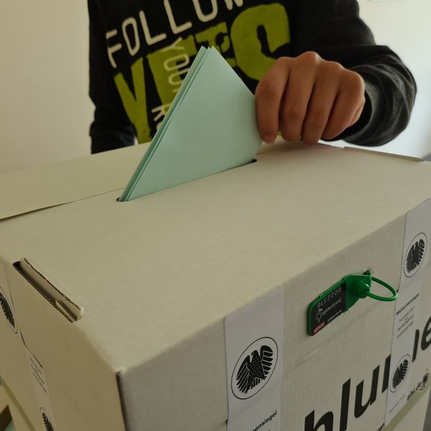 der Stimmzettel kommt in die Wahlurne